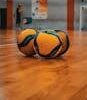Three volleyballs on a sports court in Kyiv, Ukraine. Ideal for athletic and sports themes.